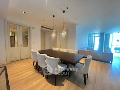 Spacious dining area with elegant lighting and modern decor in a luxurious apartment.