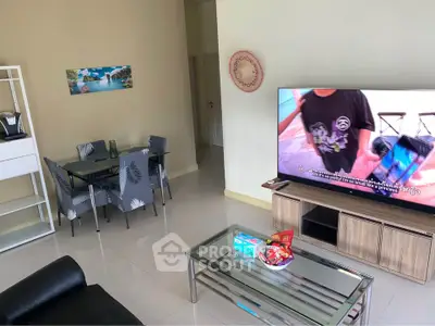 Spacious living room with modern furniture and large TV, perfect for relaxation and entertainment.