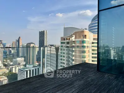 Stunning cityscape view from a modern high-rise balcony with glass railing.
