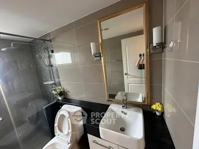 Modern bathroom with sleek fixtures and elegant mirror in a stylish real estate property.