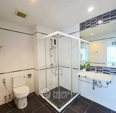 Modern bathroom with glass shower and sleek fixtures in a contemporary home.