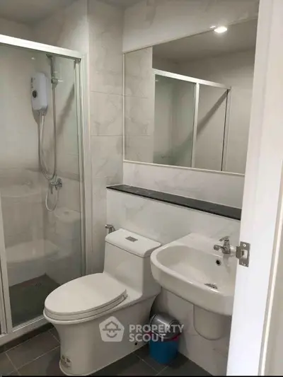 Modern bathroom with shower enclosure, sleek fixtures, and elegant tile design.