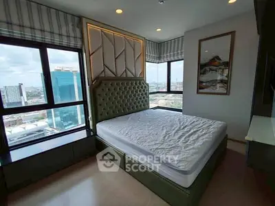 Modern bedroom with large windows offering stunning city views and stylish decor.