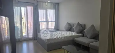 Modern bedroom with large windows and balcony access in a stylish apartment.