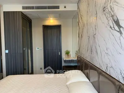 Modern bedroom with stylish marble accent wall and cozy bedding