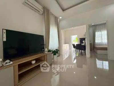 Modern living room with sleek TV unit and dining area in open layout apartment