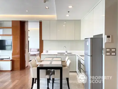 Spacious open-plan kitchen with modern appliances and a sleek dining area, perfect for entertaining guests in a luxurious urban condo.