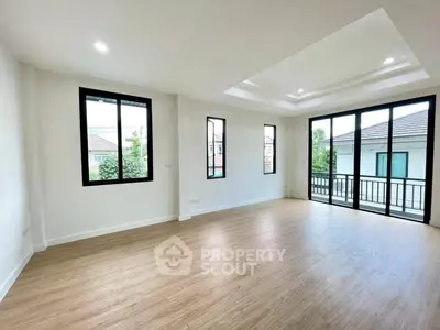 Spacious modern living room with large windows and wooden flooring
