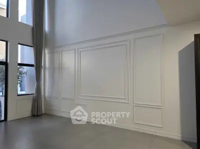 Spacious modern living room with high ceilings and large windows for natural light.