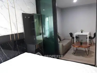 Modern studio apartment with stylish living area and sleek glass partition