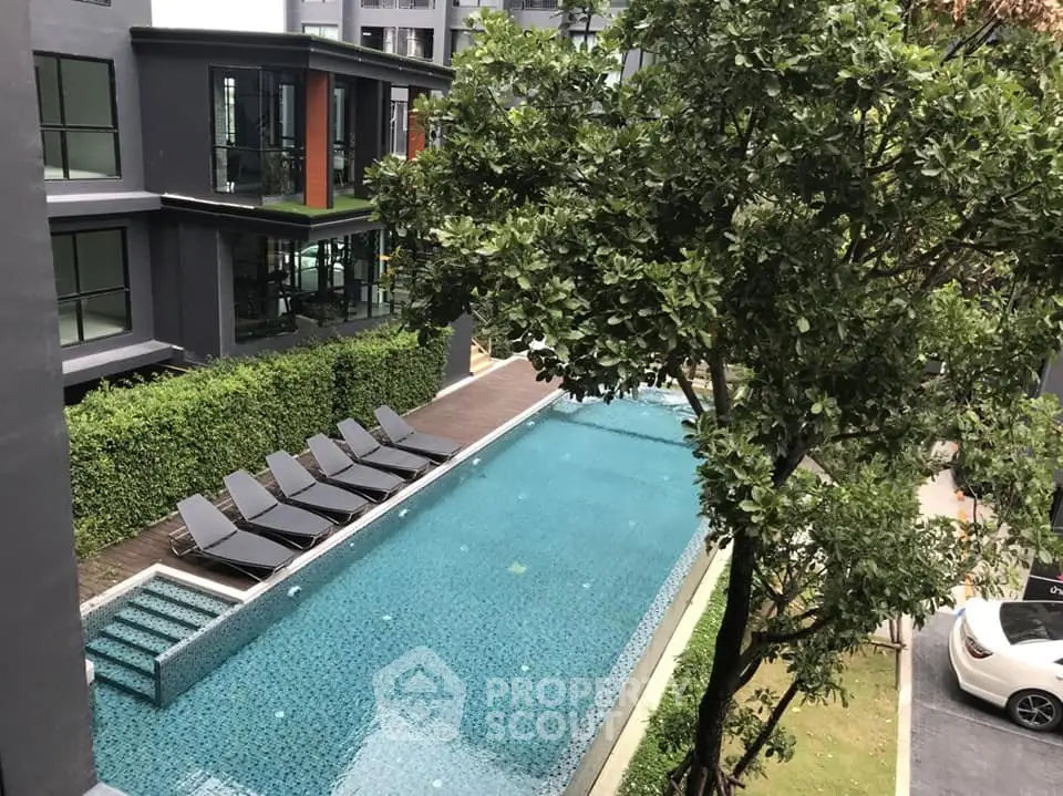 Luxurious modern apartment complex with inviting swimming pool and lush greenery.