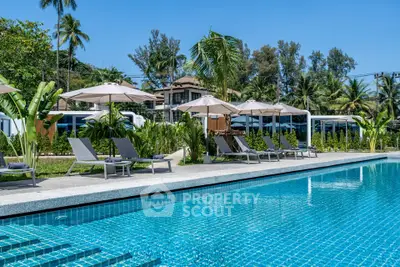 Luxurious tropical resort pool with sun loungers and palm trees, perfect for relaxation and leisure.