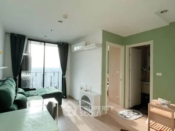 Modern living room with green accents and natural light in high-rise apartment