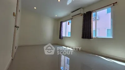 Spacious and well-lit empty room with glossy floor, ready for customization, featuring two windows with dark curtains and a neutral color palette.