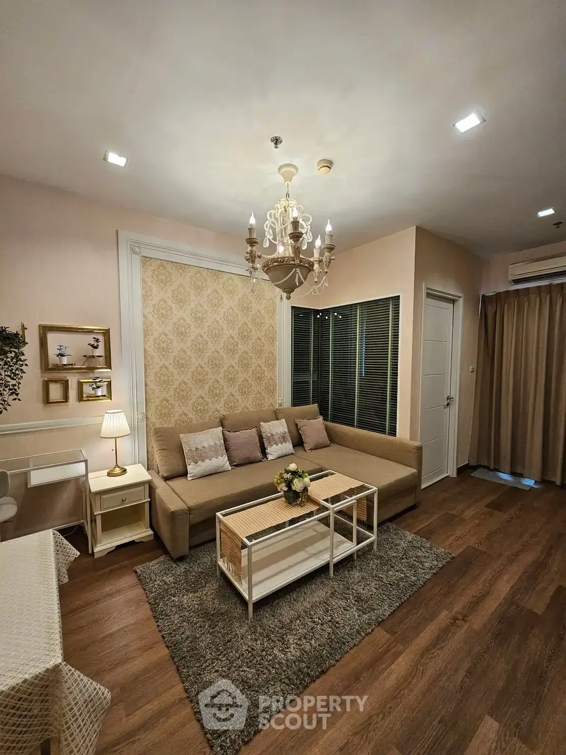 Elegant living room with chandelier, cozy sofa, and stylish decor in modern apartment.