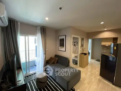 Modern living room with cozy sofa and open kitchen layout in stylish apartment.