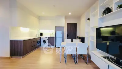 Modern kitchen with open layout, dining area, and built-in appliances in stylish apartment.