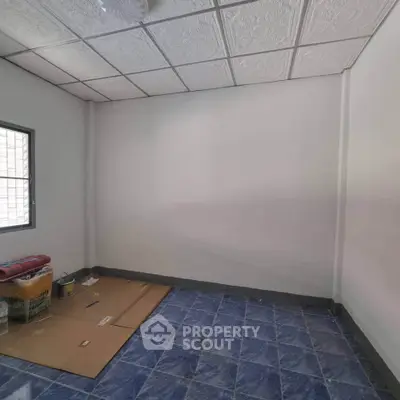 Unfurnished room with blue tiled floor and white walls, ideal for customization.