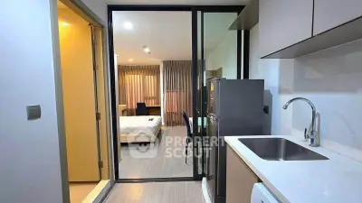 Modern studio apartment with sleek kitchen and cozy bedroom, perfect for urban living.
