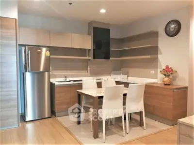 Modern kitchen with sleek cabinetry and dining area in a stylish apartment.
