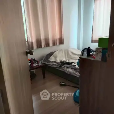 Cozy bedroom with natural light and simple furnishings, perfect for a minimalist lifestyle.