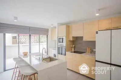 Modern kitchen with island, sleek appliances, and natural light