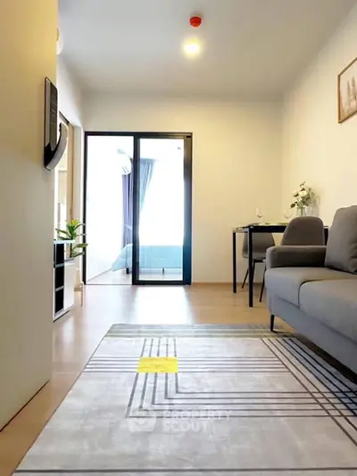 Modern living room with stylish decor and balcony access, featuring sleek furniture and natural light.