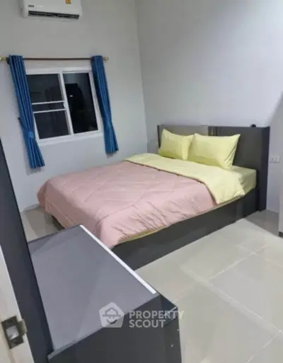Cozy bedroom with modern furnishings and air conditioning, perfect for comfortable living.