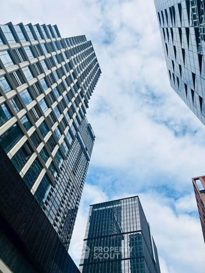 Stunning modern skyscrapers with glass facades against a bright blue sky, showcasing urban architectural elegance.