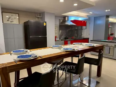 Modern kitchen with sleek appliances and stylish dining area in contemporary home.