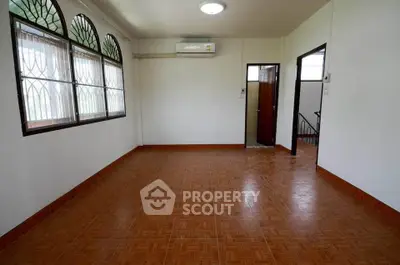 Spacious room with tiled flooring and large windows, perfect for versatile living space.