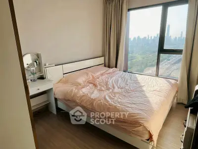 Cozy bedroom with city view, featuring a comfortable bed and natural light.