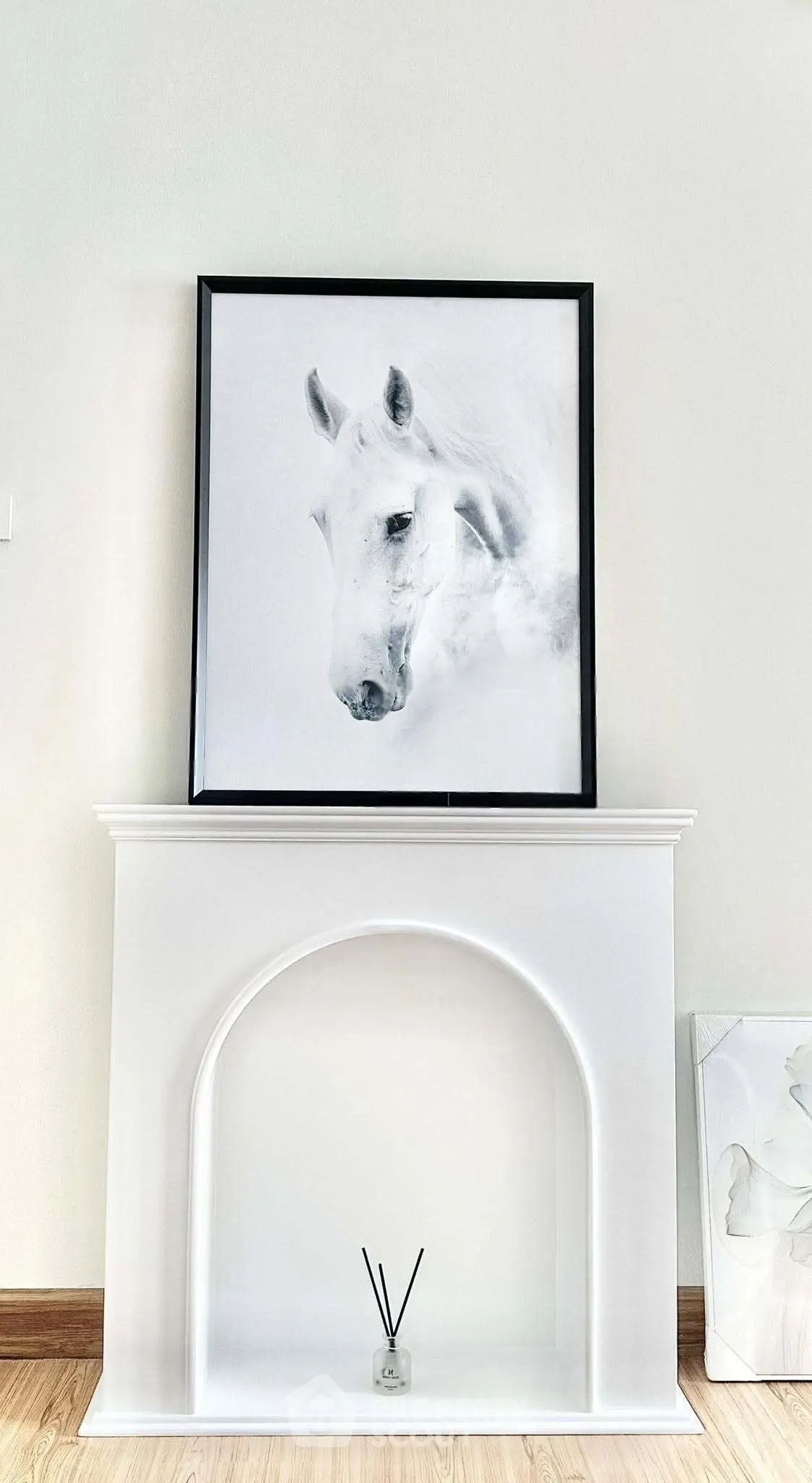Elegant interior with framed horse artwork above a decorative white mantelpiece.