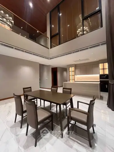 Luxurious modern dining area with high ceilings and elegant furnishings in a spacious open-plan layout.