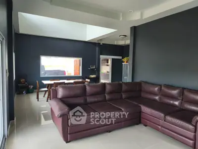 Spacious modern living room with large sectional sofa and dining area, perfect for family gatherings.