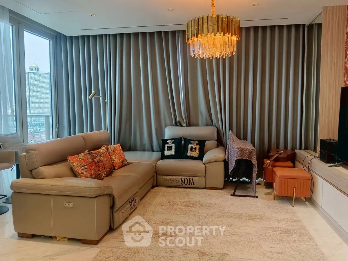 Luxurious living room with elegant chandelier and modern leather sofas in high-rise apartment.