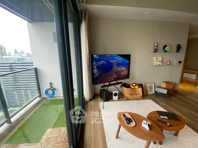Modern living room with balcony view, featuring stylish decor and entertainment setup.