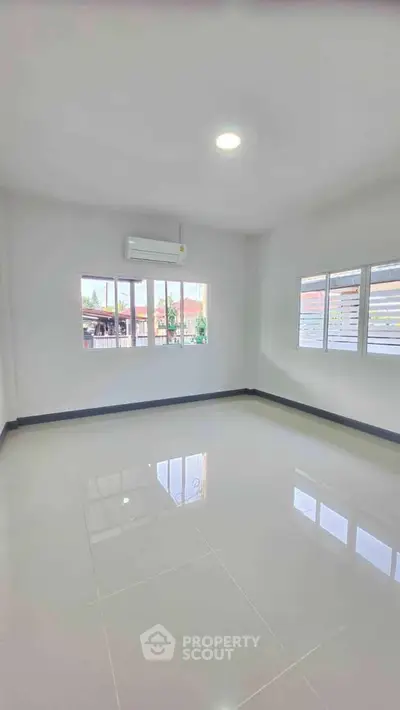 Spacious empty room with large windows and glossy tiled floor, perfect for customization.
