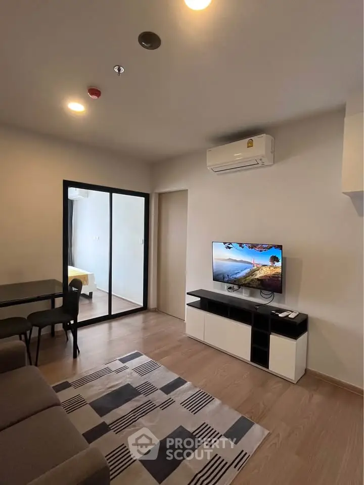 Modern living room with sleek design and balcony access in a stylish apartment.