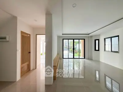 Spacious modern living room with large windows and glossy tiled floors