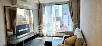 Modern living room with large window and city view, featuring stylish furniture and air conditioning.