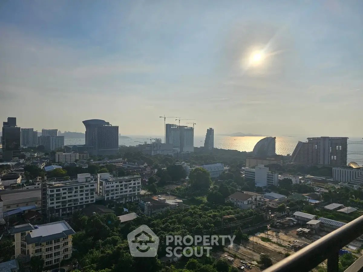 Stunning cityscape view with ocean horizon and modern architecture at sunset.