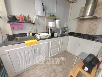 Modern kitchen with sleek cabinetry and gas stove, featuring efficient storage solutions.