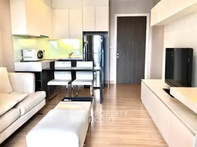 Modern living room with sleek furniture and open kitchen layout in a stylish apartment.