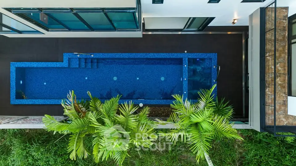 Luxurious modern home with private swimming pool and lush greenery, perfect for relaxation and entertainment.