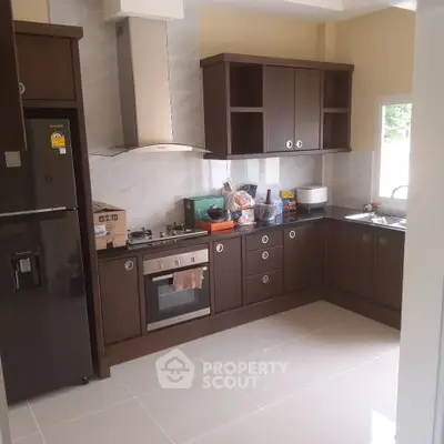 Modern kitchen with dark wood cabinets and stainless steel appliances