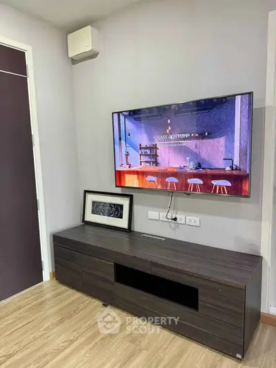 Modern living room with wall-mounted TV and sleek wooden cabinet