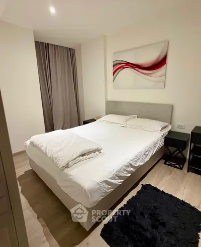 Modern bedroom with stylish decor and cozy ambiance, featuring a comfortable bed and elegant artwork.