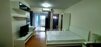 Modern bedroom with balcony view, sleek furniture, and ample natural light.