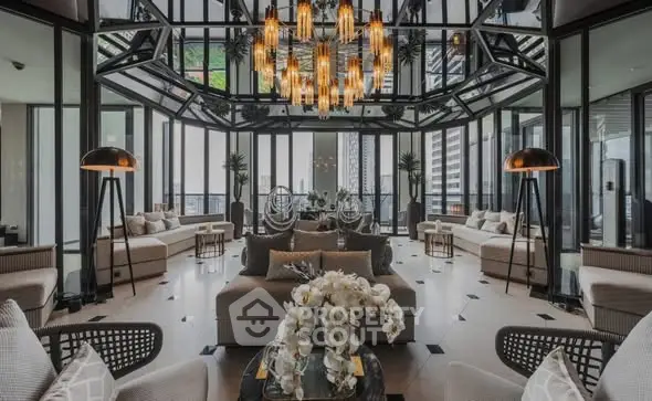 Luxurious modern living room with glass walls and elegant chandelier in high-rise building.
